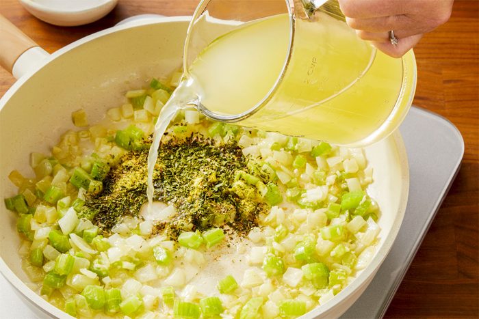 3/4th shot of Stiring in broth from measuring cup; chicken bouillon; parsley; thyme and pepper