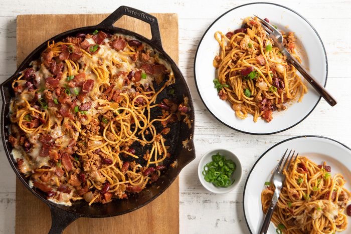 Cowboy Spaghetti made in a cast iron skillet and served in white plates