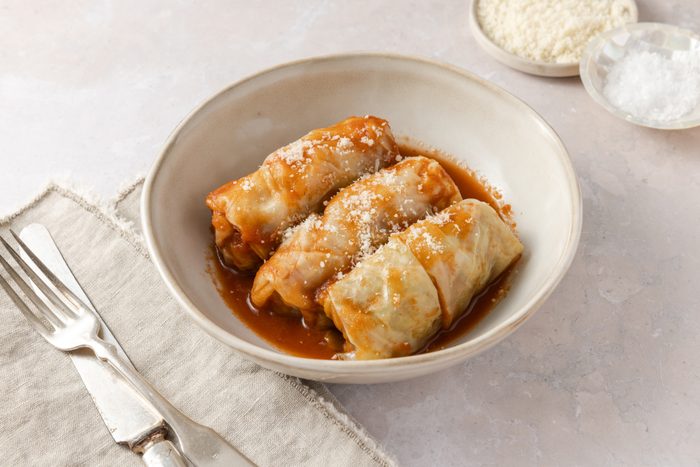 Cabbage rolls served in bowl topped with parmesan cheese.