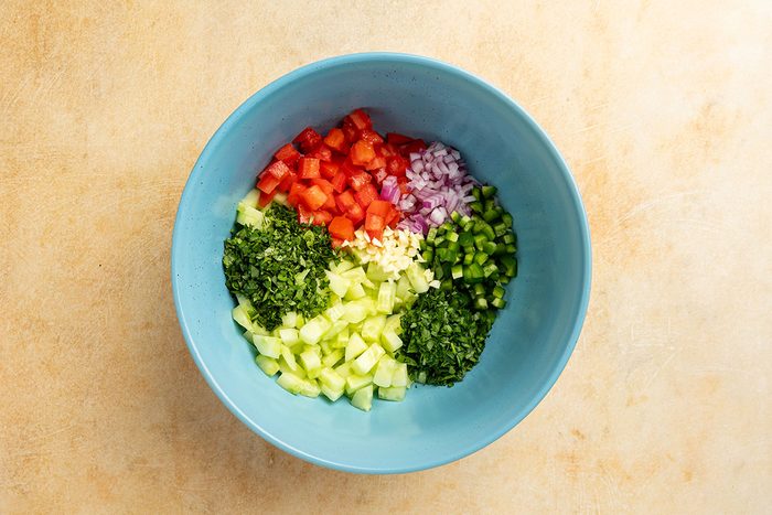 vegetables and herbs in a mixing bowl.