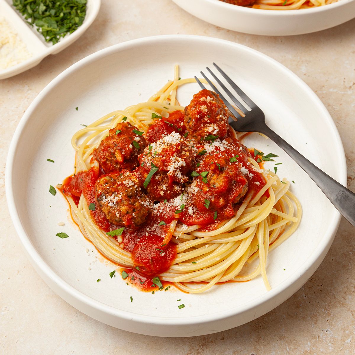 Single servings of Taste of Home Slow-Cooked Italian Meatballs garnished with parmesan cheese and parsley.