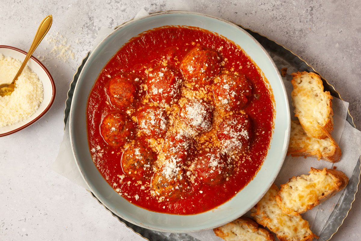 Full yield of Taste of Home Eggplant Parmesan Meatballs with sliced baguette with melted cheese