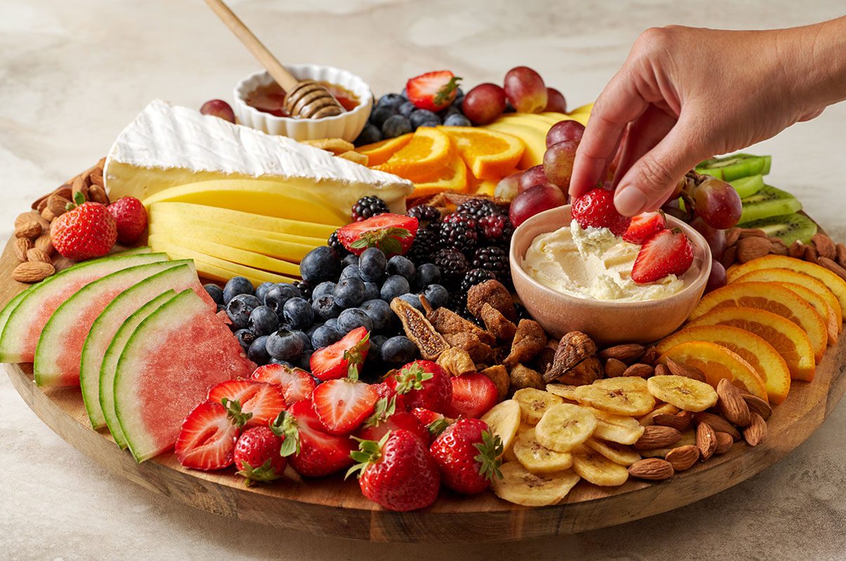A close-up shot of the Fruit and Cheese Platter, focusing on the colorful fruits and creamy cheeses, arranged neatly on the platter, by Taste of Home.