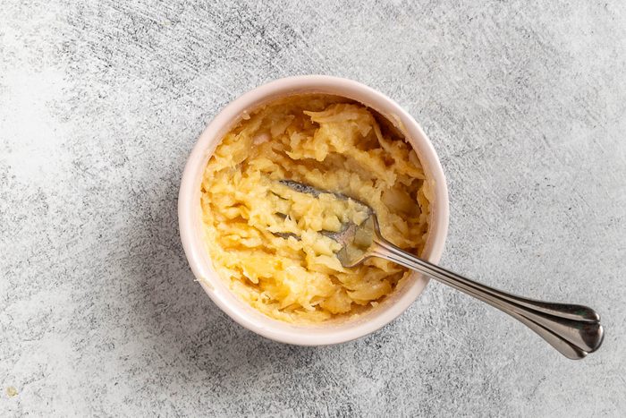 Taste of Home Garlic Soup photo of the roasted garlic smashed in a small bowl.