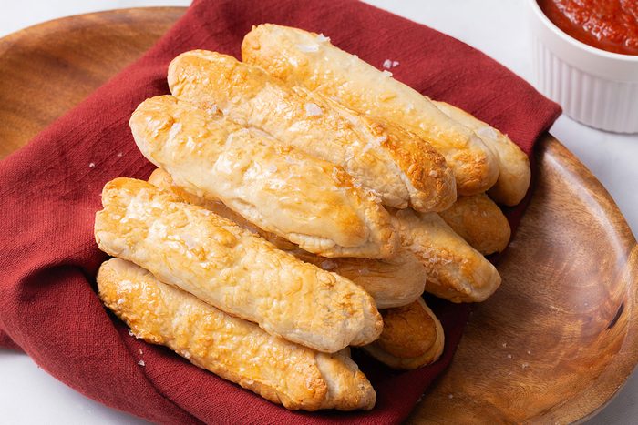 Homemade Breadsticks on a wooden platter for Taste of Home