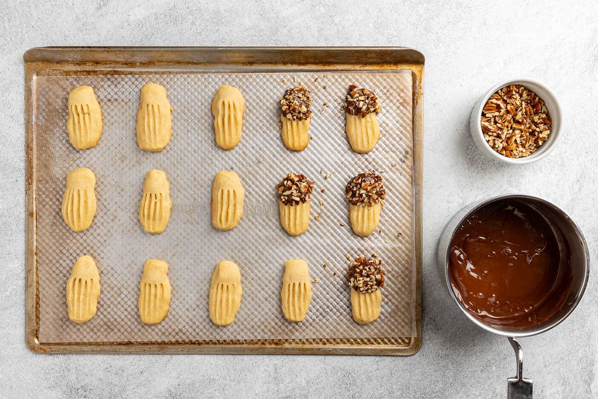 cookies dipped in chocolate sauce and sprinkled with nuts.