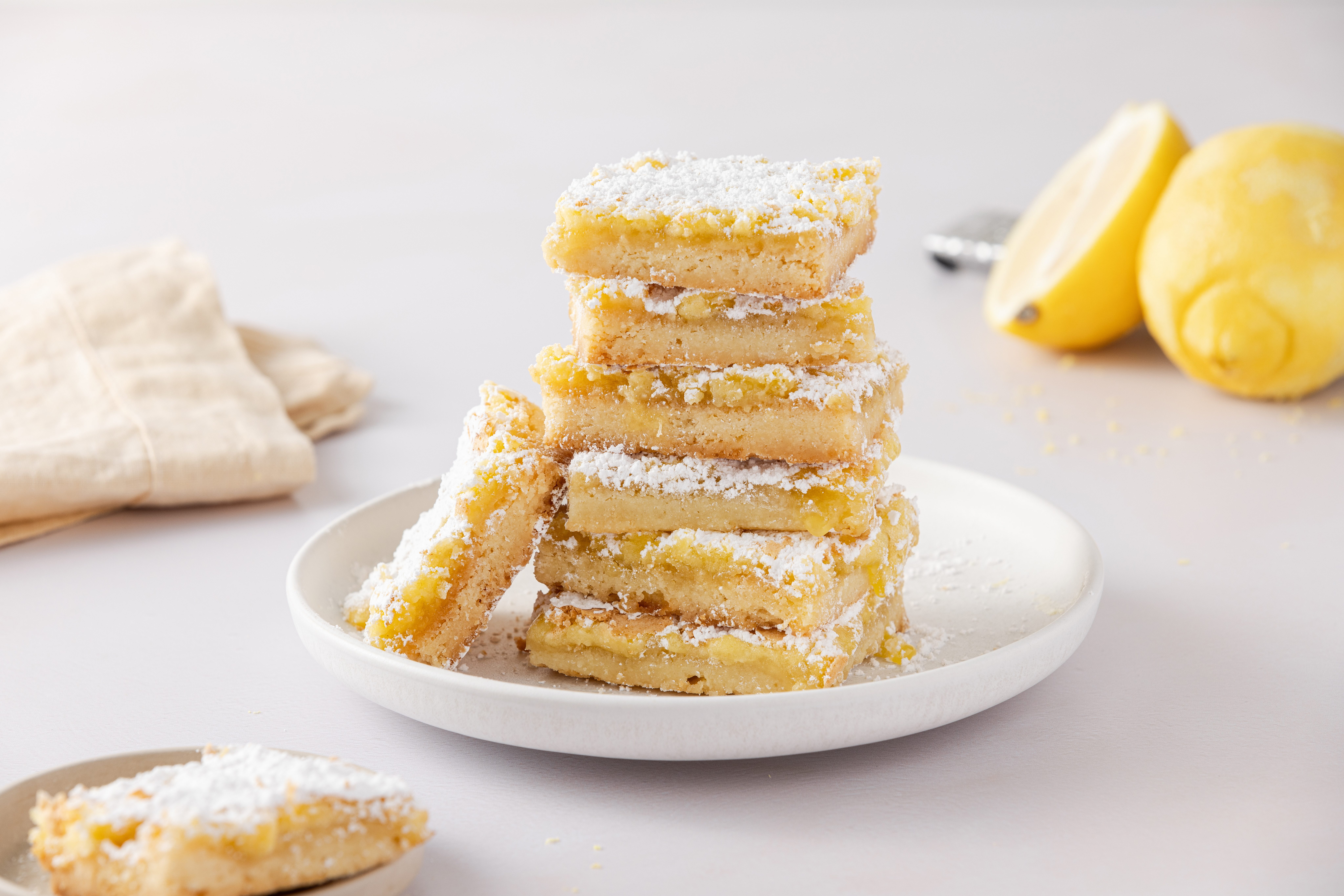 Lemon bars cut into squares and served on plate.