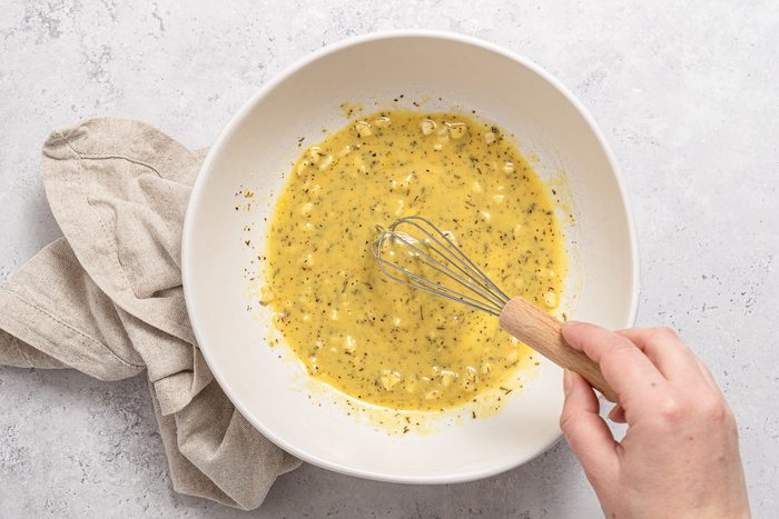 Garlic, Herbs, Mustard, Lemon And Oil Mixed Inside Bowl