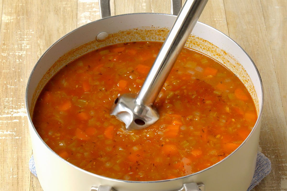 immersion blender mixing the soup