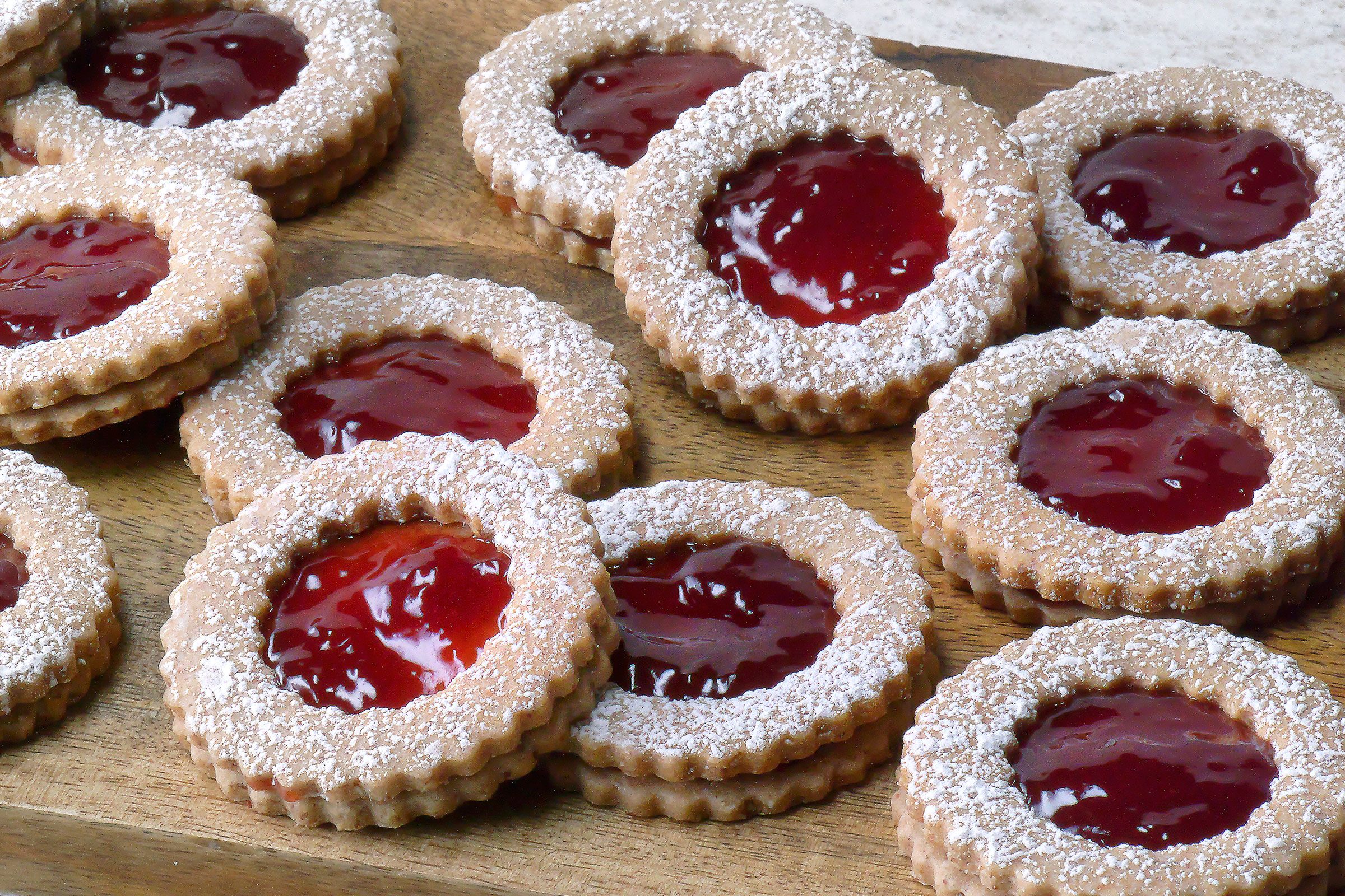 Linzer Cookies with confectioners sugar placed on a wooden tray