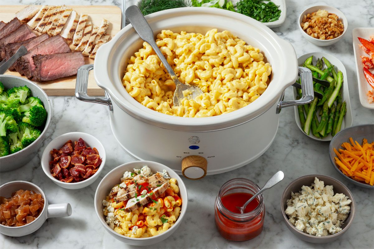 3/4th Shot Of Mac And Cheese Bar Served With Bowls Filled With Topping Options.