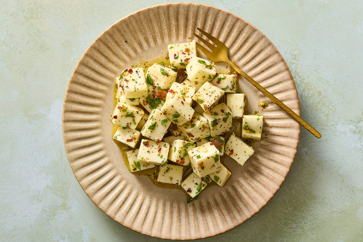 Overhead shot of a plate of marinated mozzarella with a small fork