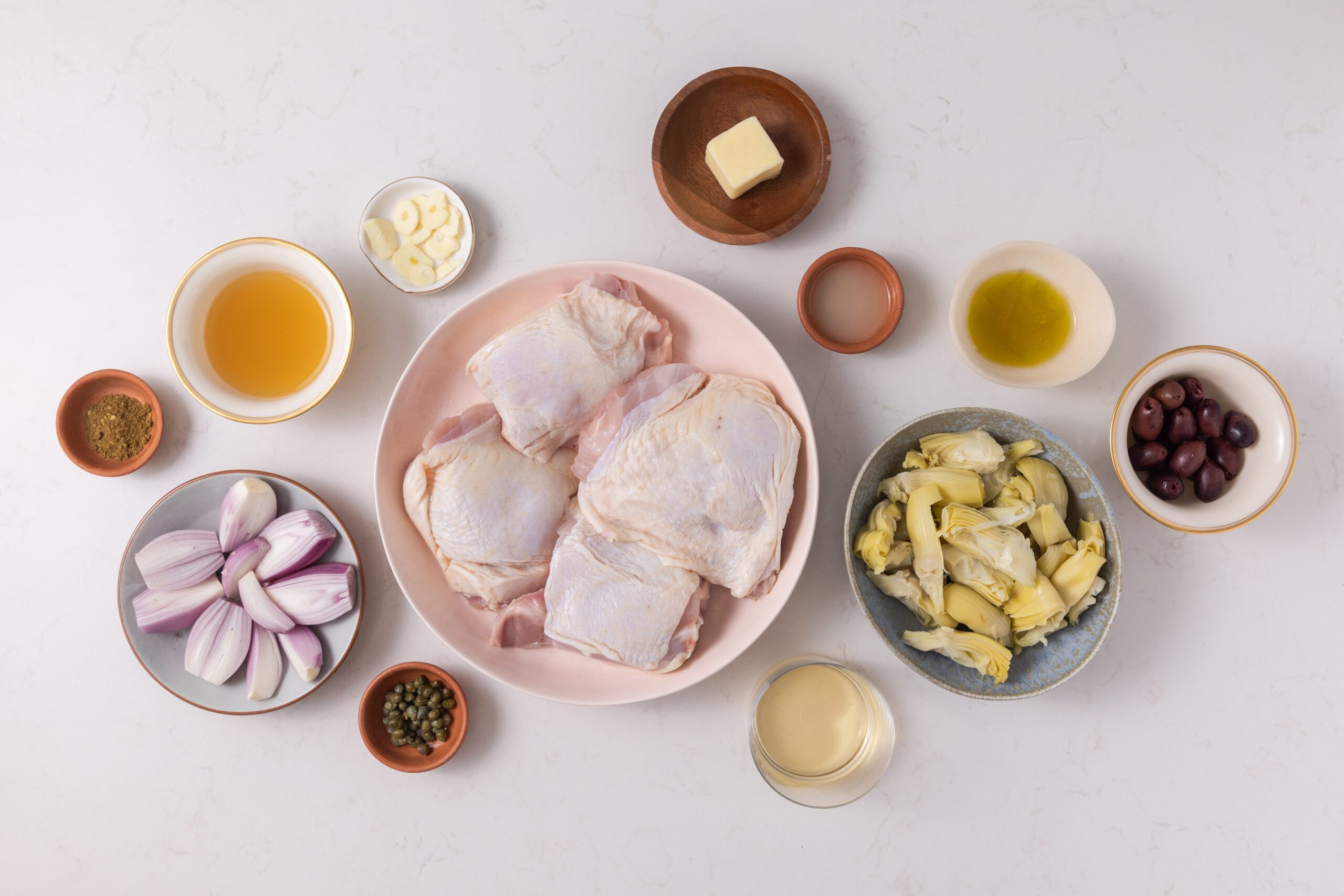 Ingredients for mediterranean chicken thighs on kitchen counter.