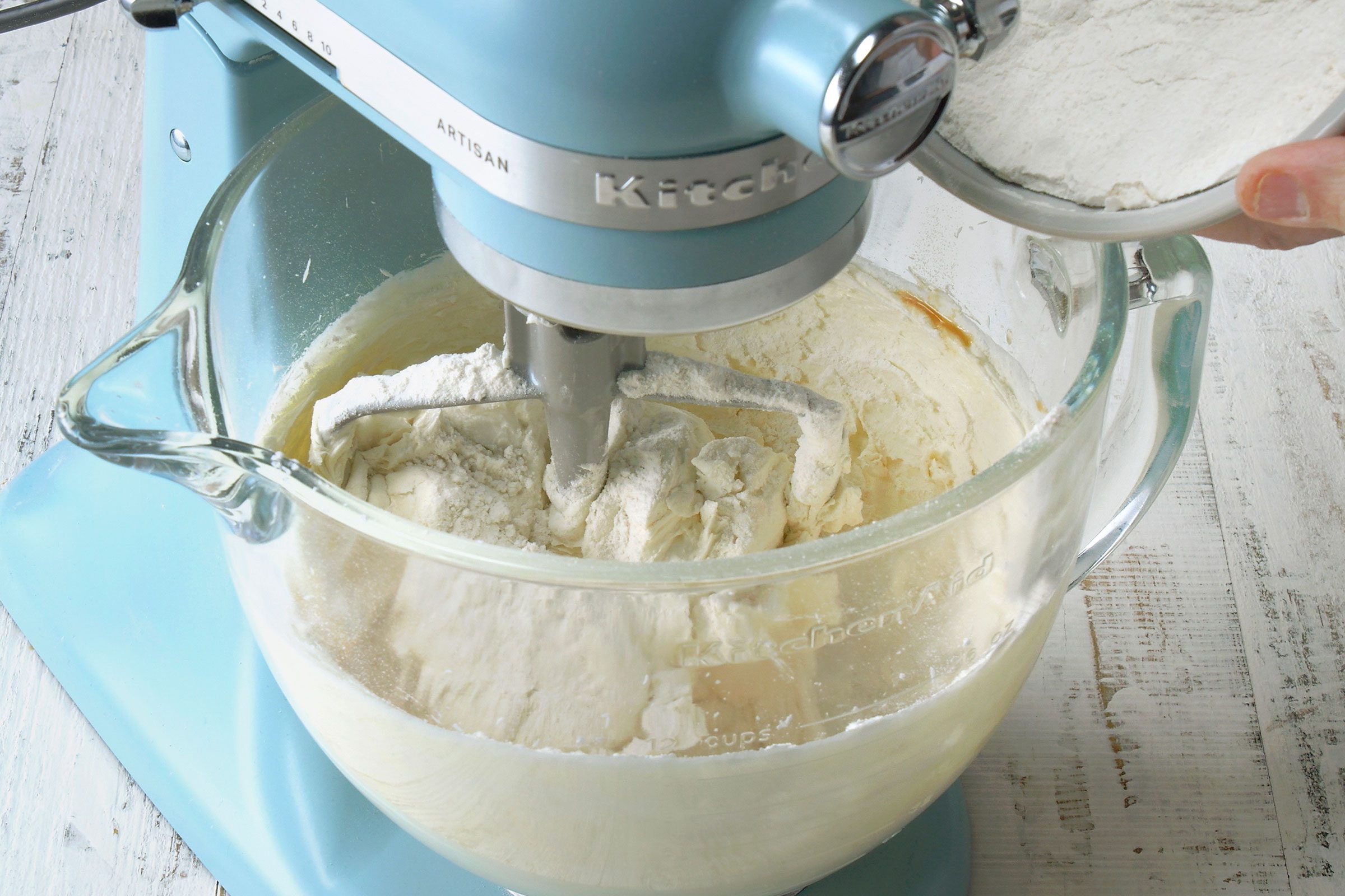 Butter and sugar mixture combined with flour in a glass bowl
