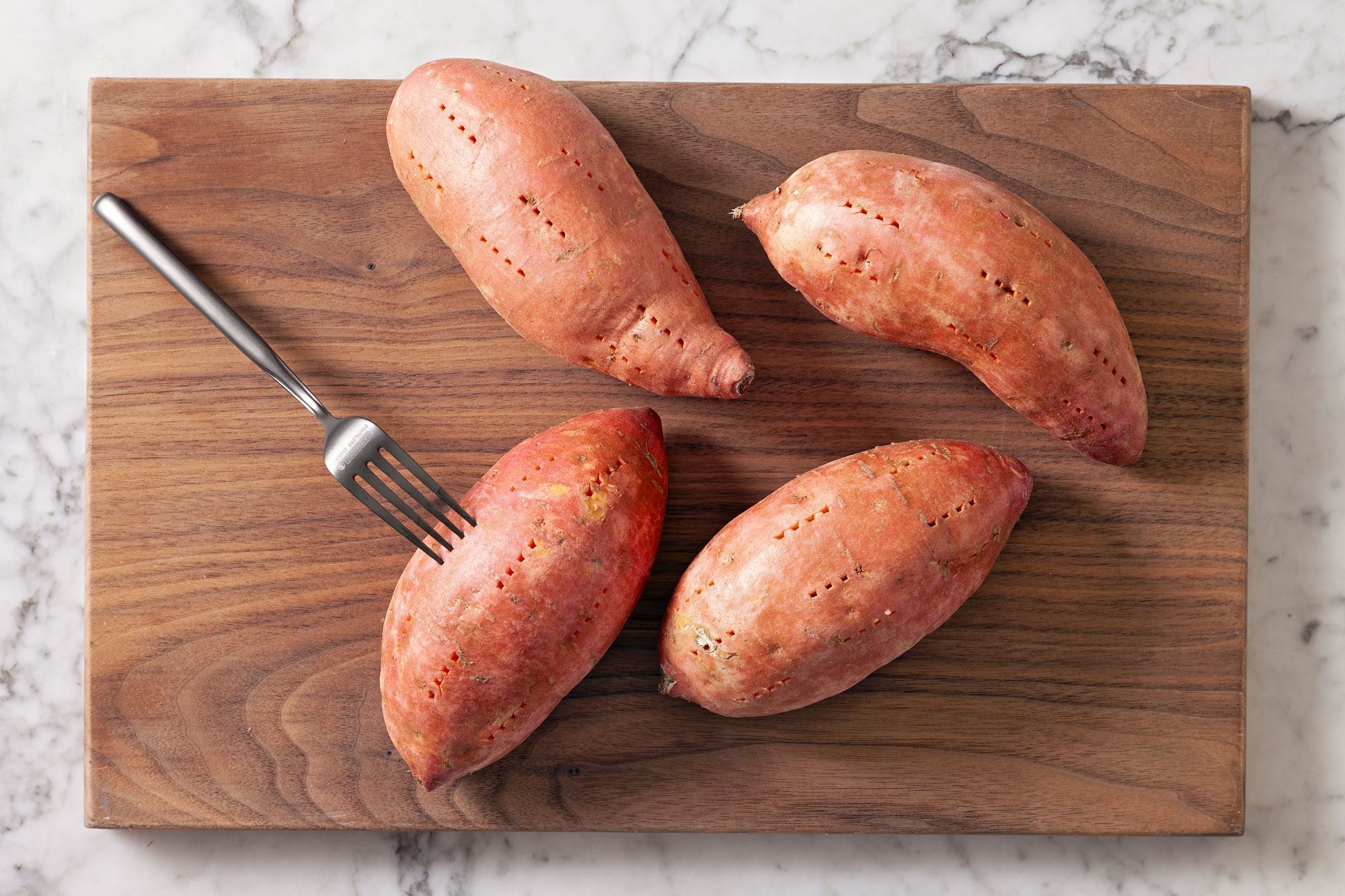 Use a fork to poke holes into sweet potatoes