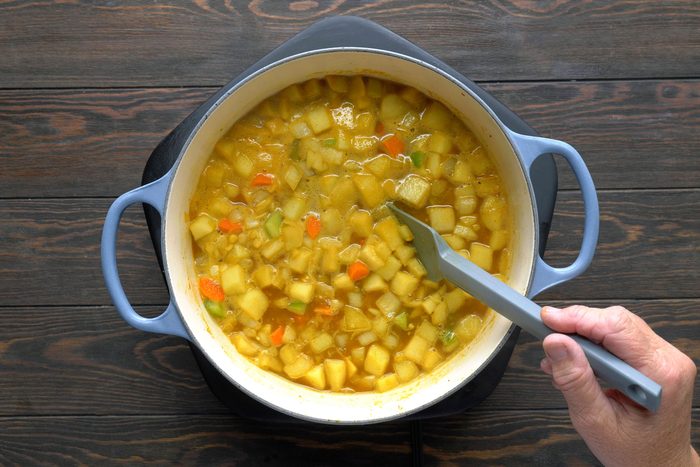 Broth, soaked lentils and rice on a low simmer in a dutch oven