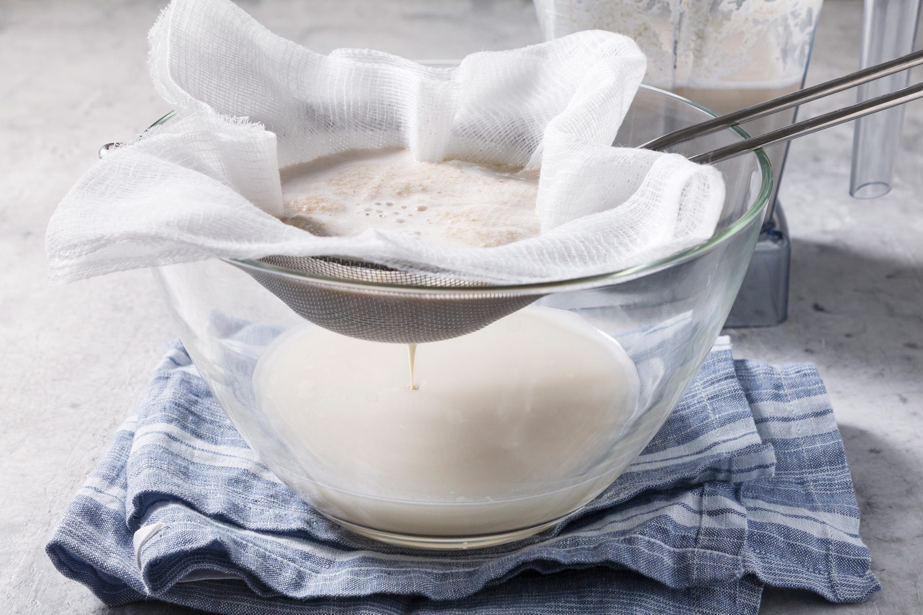Straining the mixture into a large glass bowl using a fine mesh sieve.