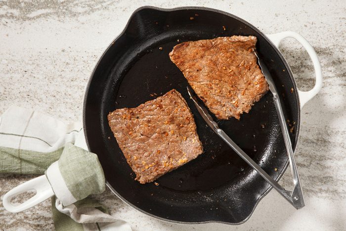 steaks cooking in a pan