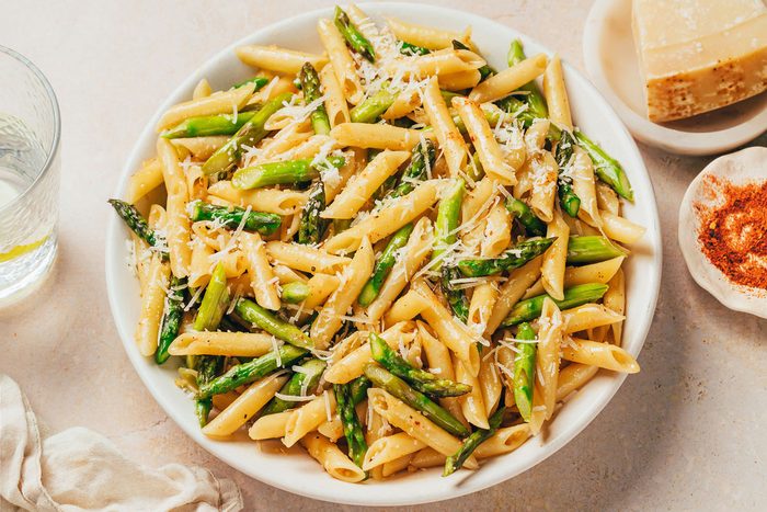 Pasta with asparagus served in a large bowl topped with parmesan recipe by Taste of Home