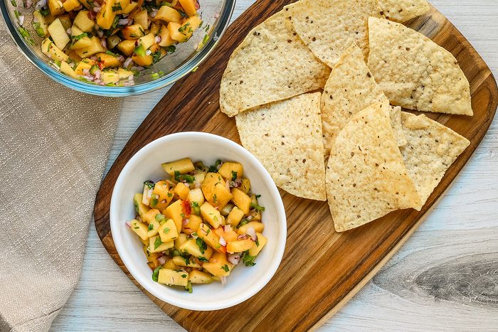Fresh peach salsa with tortilla chips for snacking.
