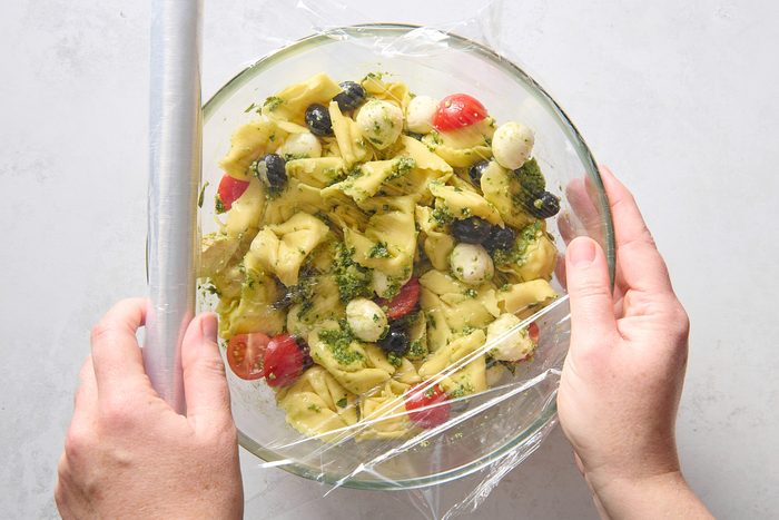 Covering the bowl of pesto tortellini salad ready for chilling
