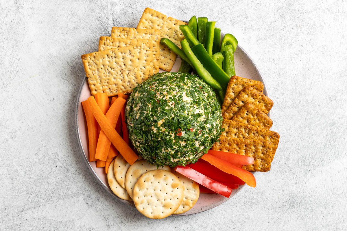 Taste of Home Pimento Cheese Ball photo of the formed cheese ball rolled in fresh parsley and served with assorted crackers and vegetables.