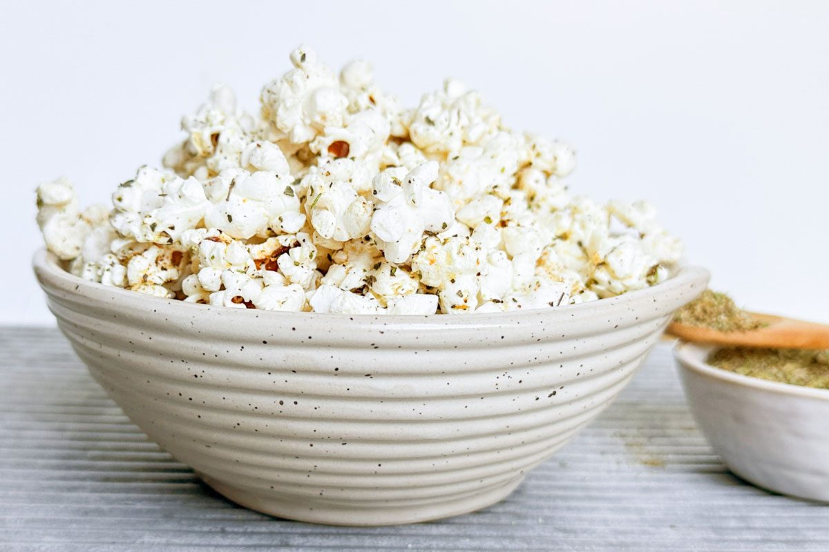 Popcorn with Taste of Home Popcorn Seasoning in a bowl on a ribbed metal tray