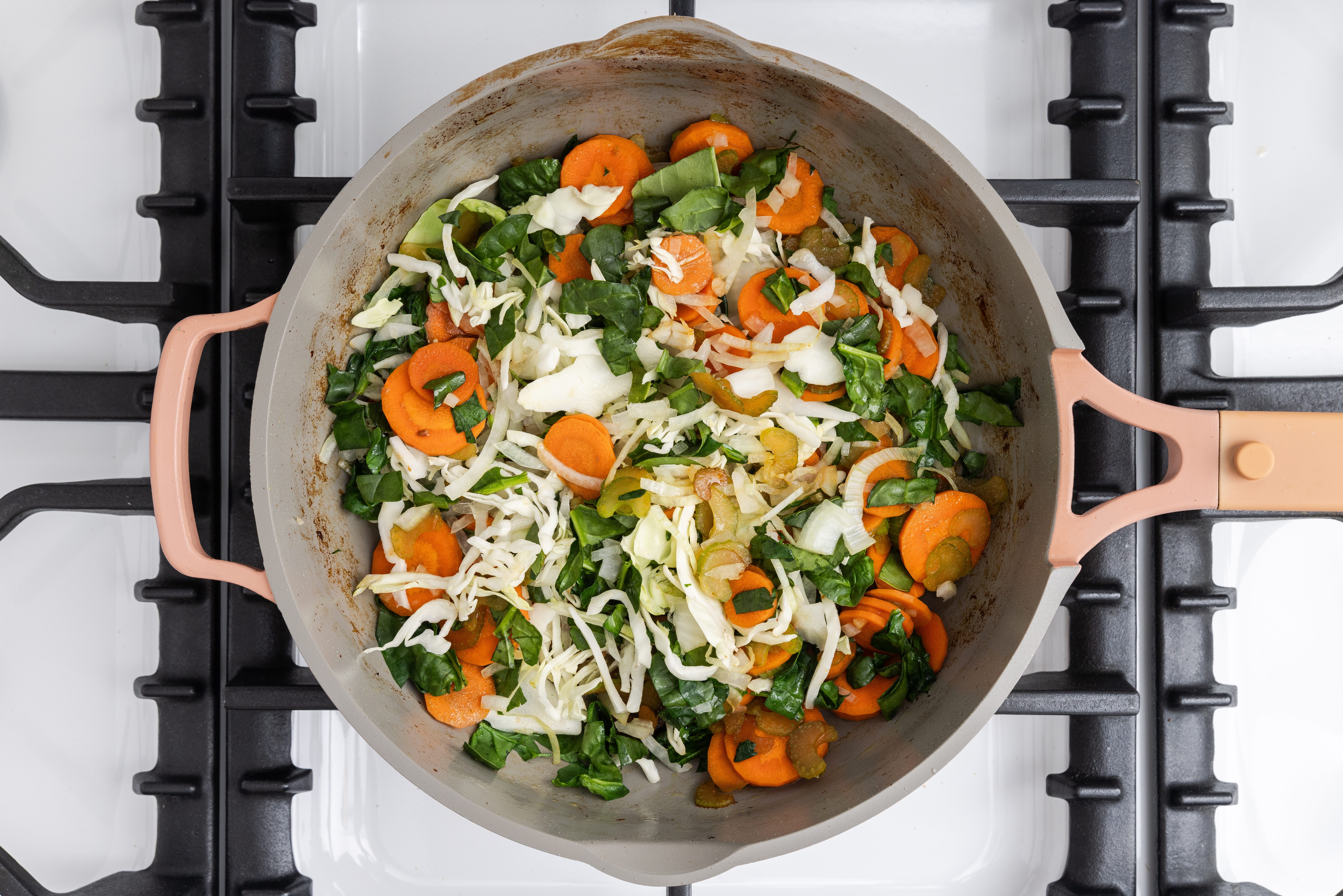 Vegetables being cooked in skillet.