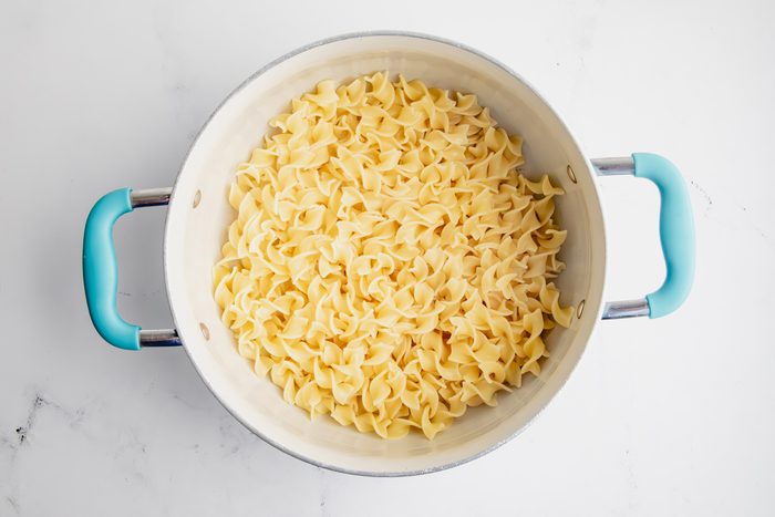 Overhead shot for Taste of Home Pork Chops and Noodles, noodles cooked in a large saucepan.