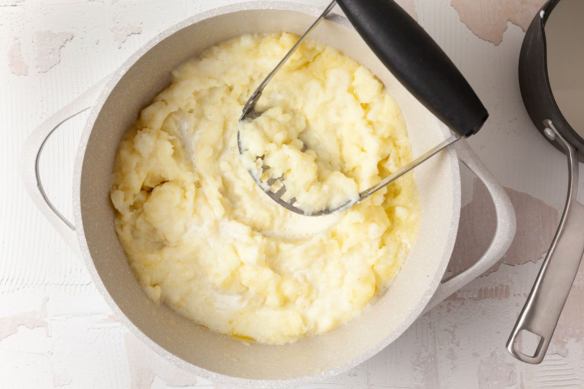 Step 3 of Taste of Home Potato Puree is to Add the warm milk and cream mixture, a little bit at a time, to the Dutch oven with the buttered potatoes, gently mashing until everything has combined. Send the potato mixture through a ricer, then top the purée with the remaining 2 tablespoons of butter to serve.