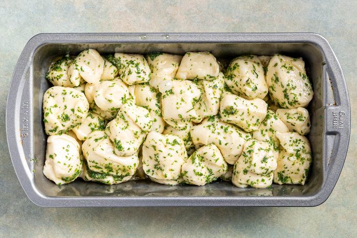 Taste of Home Pull Apart Garlic Bread photo of coated dough in a loaf pah.