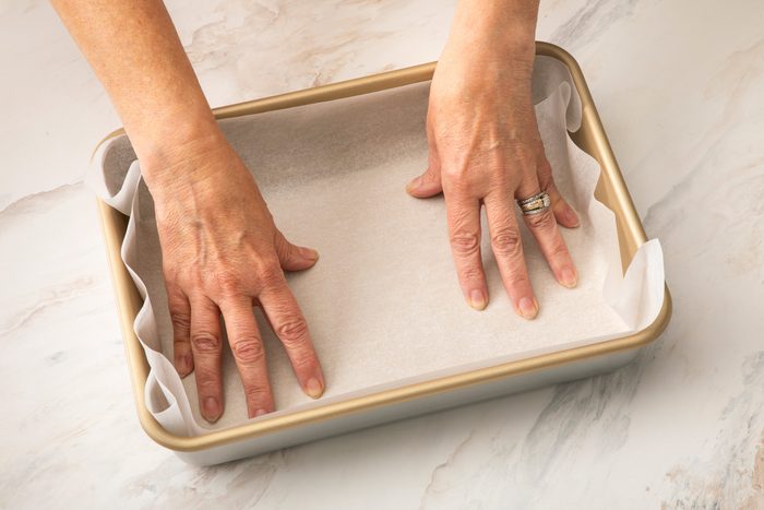 Lining a 13x9-inch baking pan with parchment paper