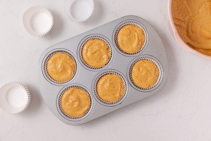 Pumpkin cupcakes batter in muffin cups, ready to be baked.