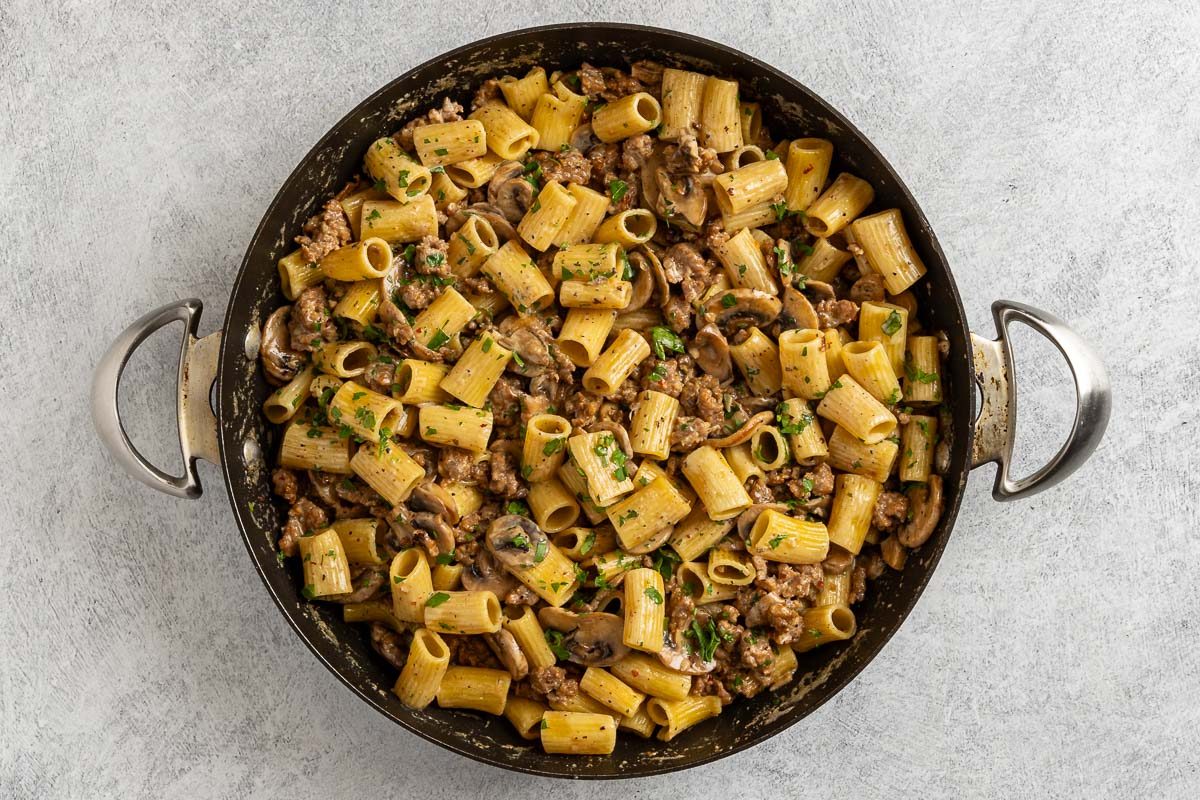 Taste of Home Sausage and Mushroom Pasta photo of the sausage and pasta added back to the skillet with the mushroom cream sauce.