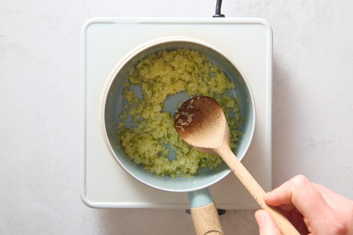 Cooking the diced onions in a saucepan until soft
