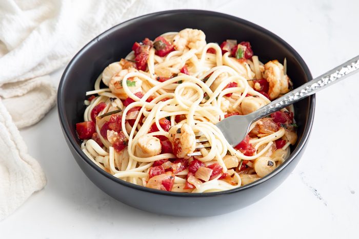 Close up beauty shot for Taste of Home Seafood Linguine being served in a black bowl.
