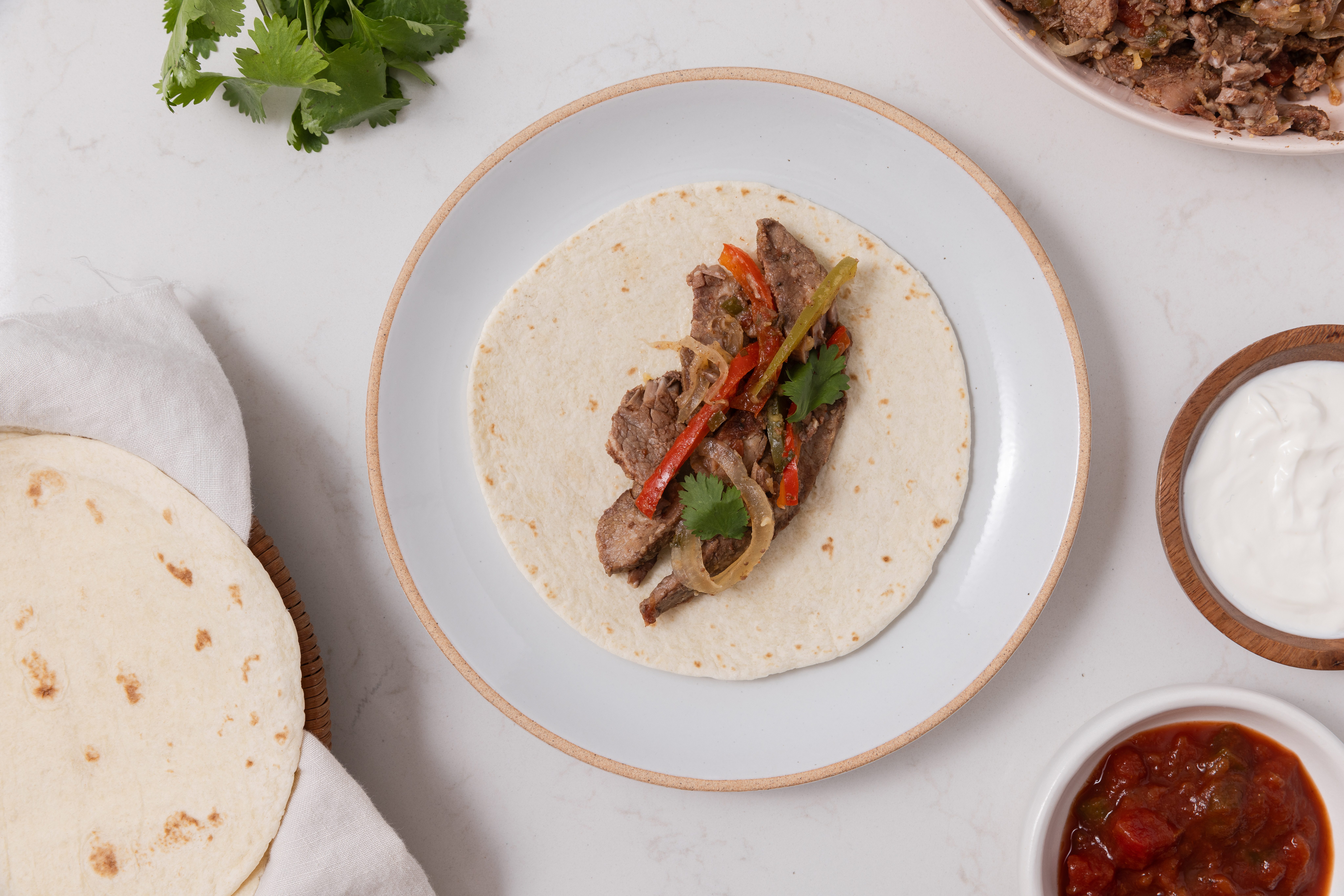 Fajitas being assembled on plate.
