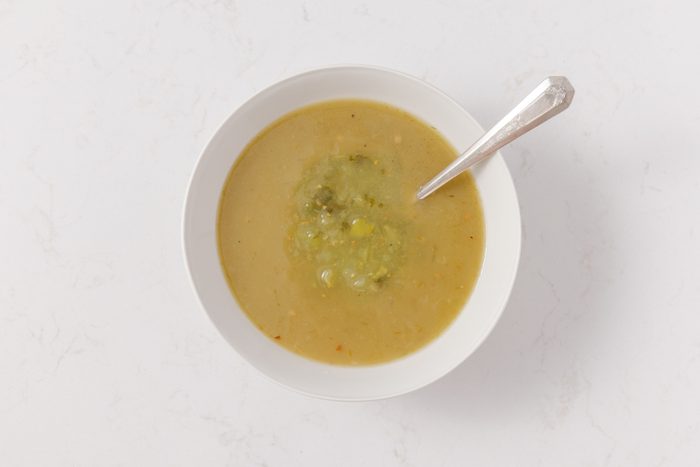 Green enchilada sauce and salsa verde being combined in mixing bowl.
