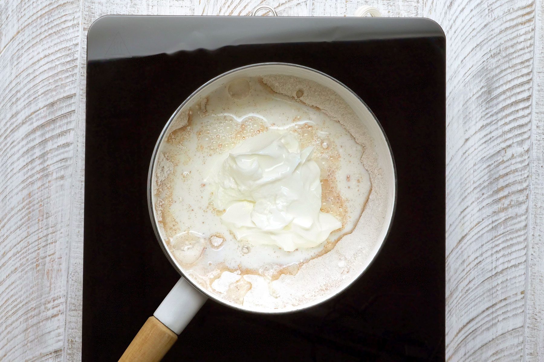 Sugar, cornstarch, salt, cloves and cinnamon whisked together with milk and sour cream in a saucepan.