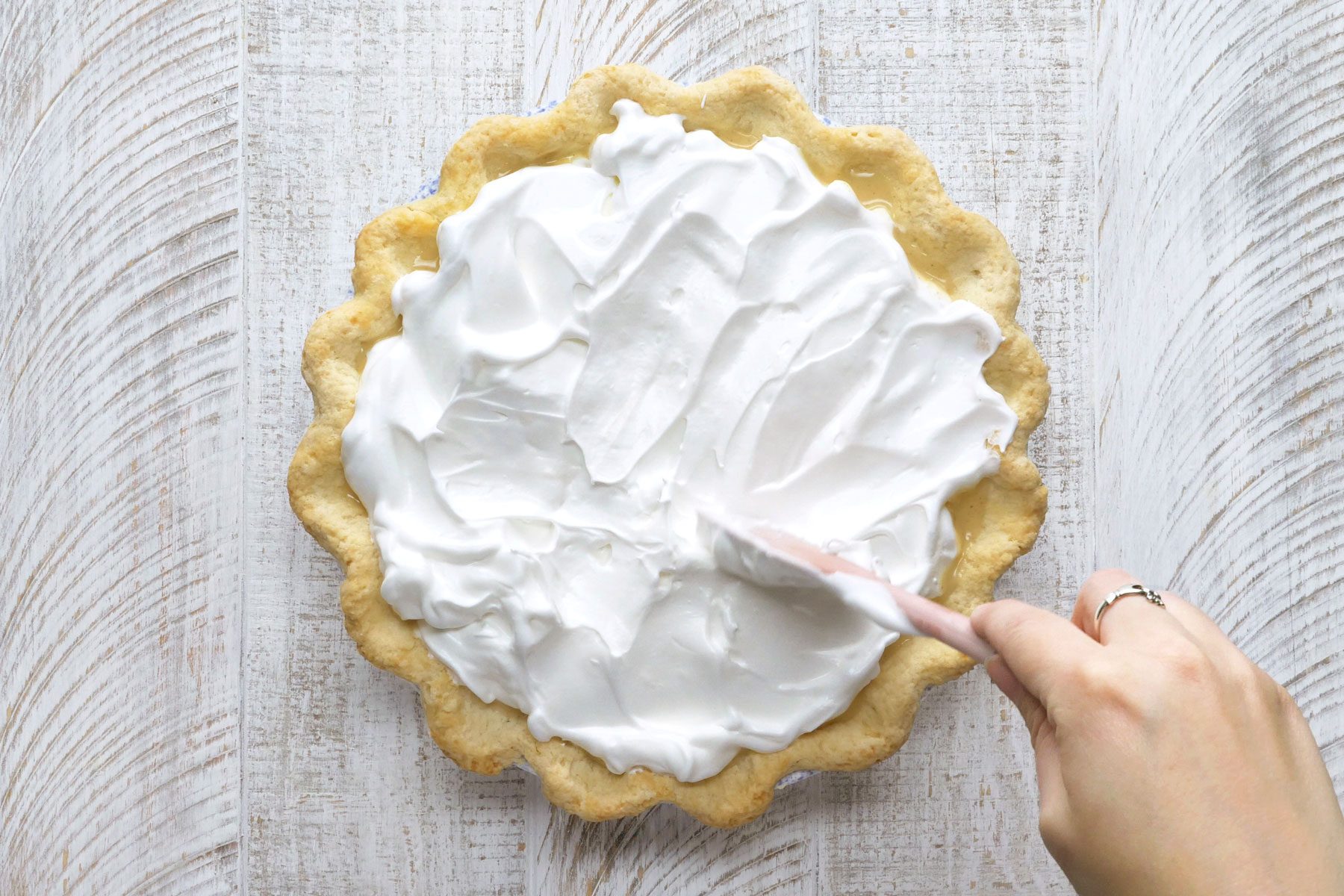 Meringue being spread over hot filling.