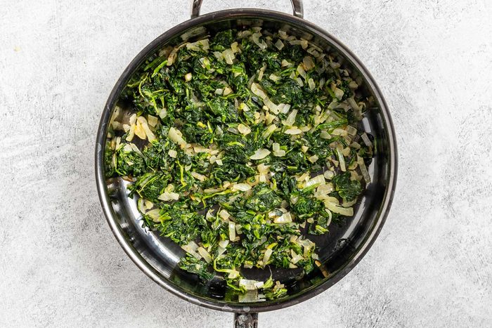Taste of Home Spinach Bread photo of cooking the onion, garlic and spinach.