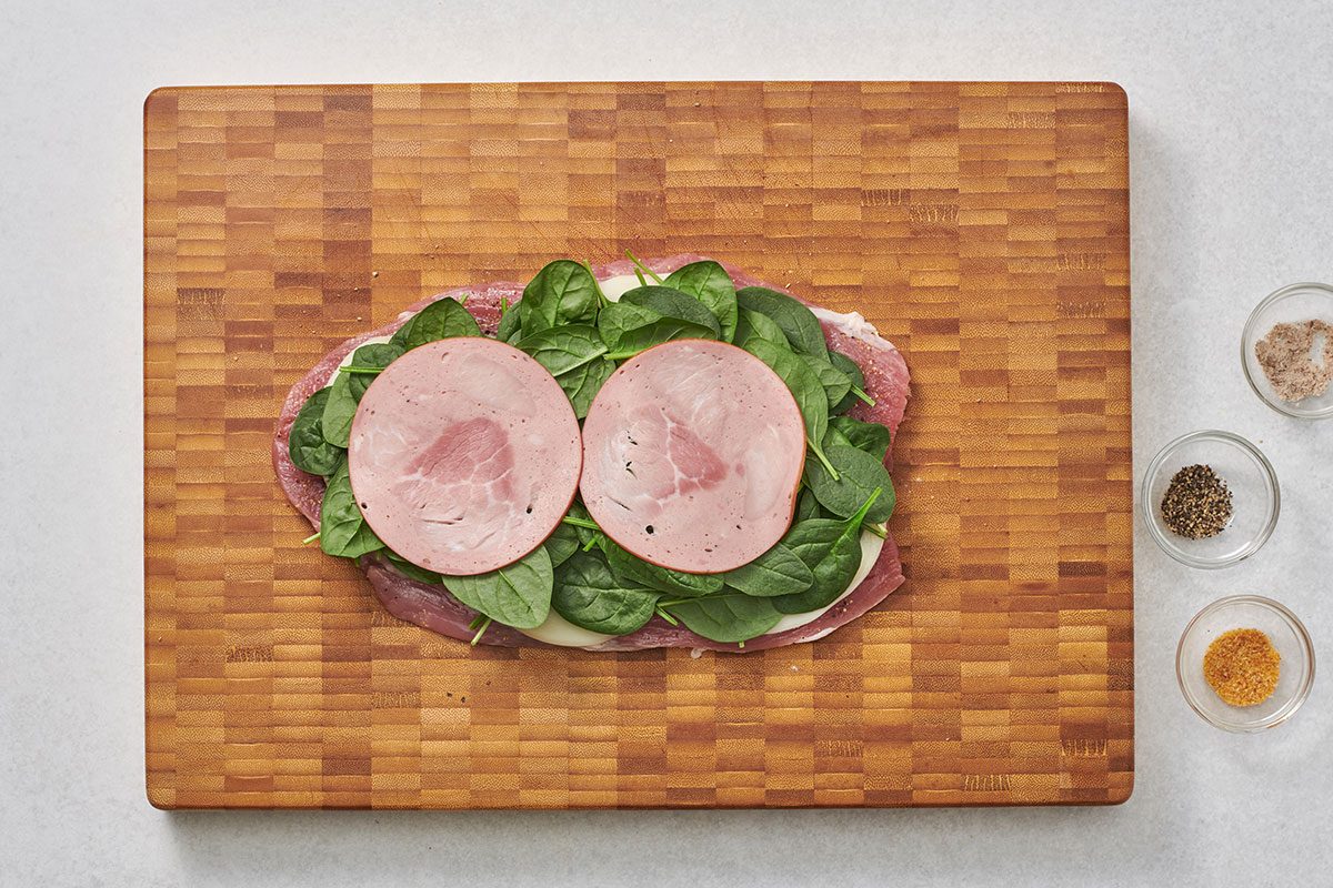 Flattened pork tenderloin layered with cheese spinach and ham