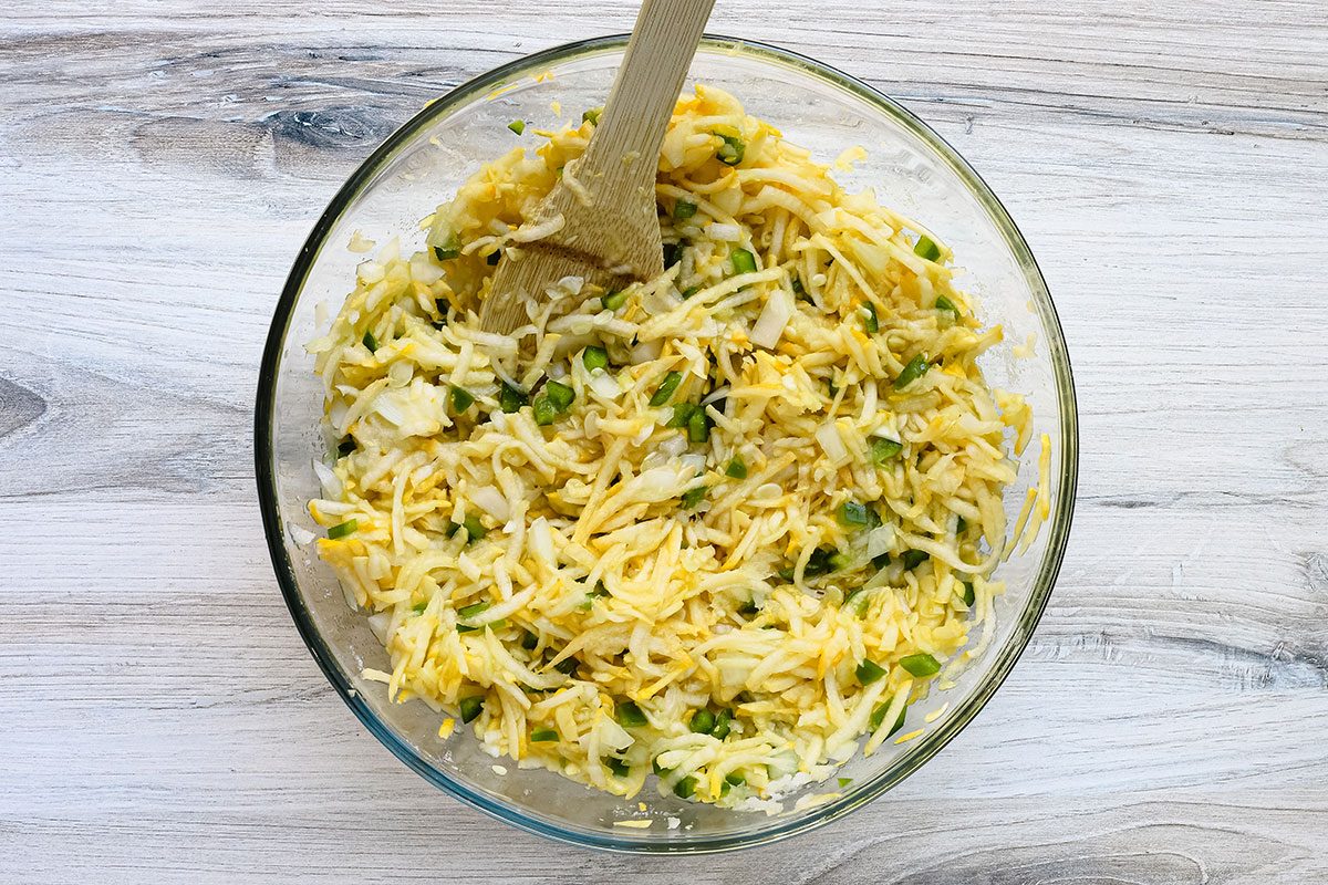 Squash relish preparation: grated squash, peppers, and onions in a large bowl.