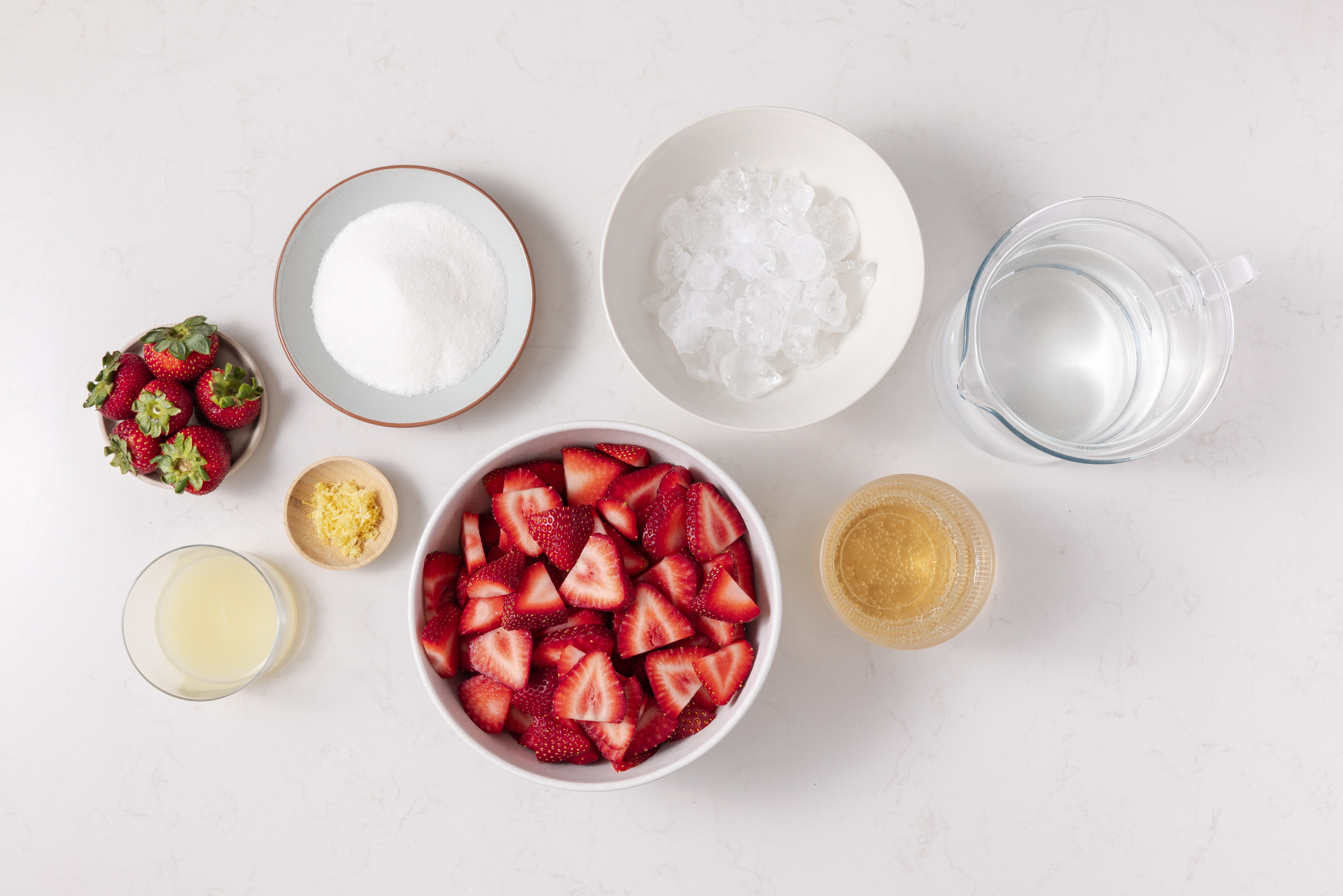 Ingredients for strawberry drink on kitchen counter.