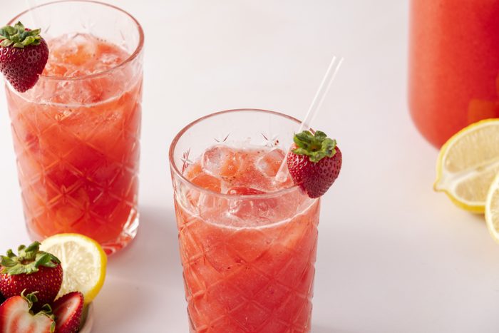 Strawberry drink served in tall glasses and pitcher of drink in the background.