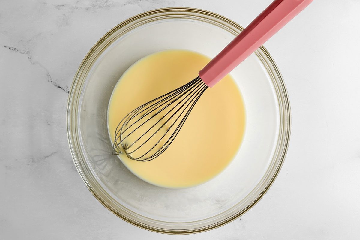 Filling for Taste of Home Strawberry Shortcake Trifle in a glass bowl with whisk