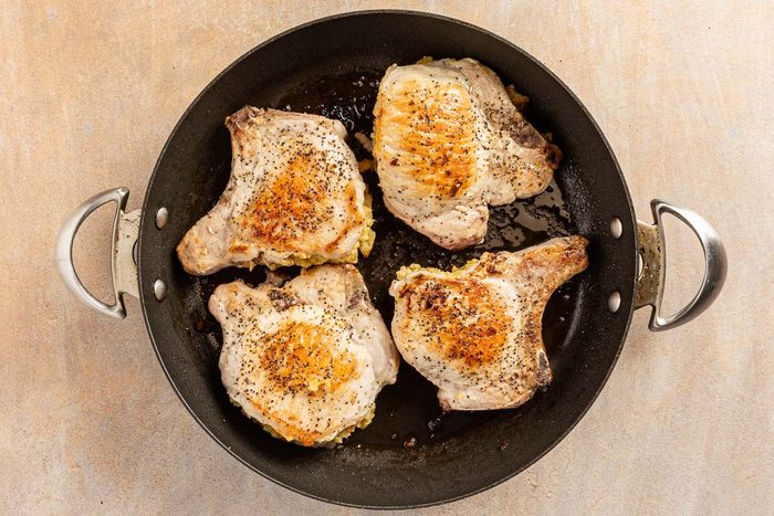 Stuffing Stuffed Pork Chops cooking in a skillet