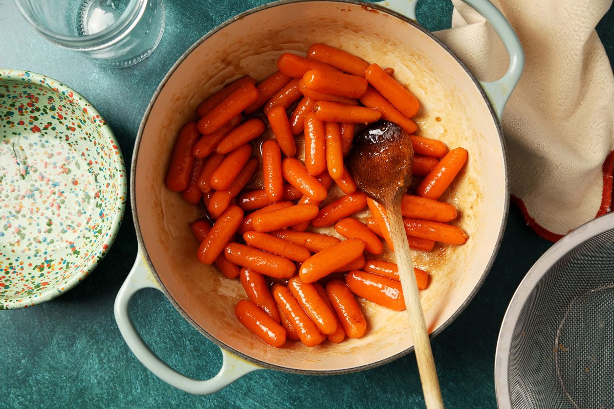 Process of making Taste of Home's Glazed Carrots served on a large dish with a green surface.