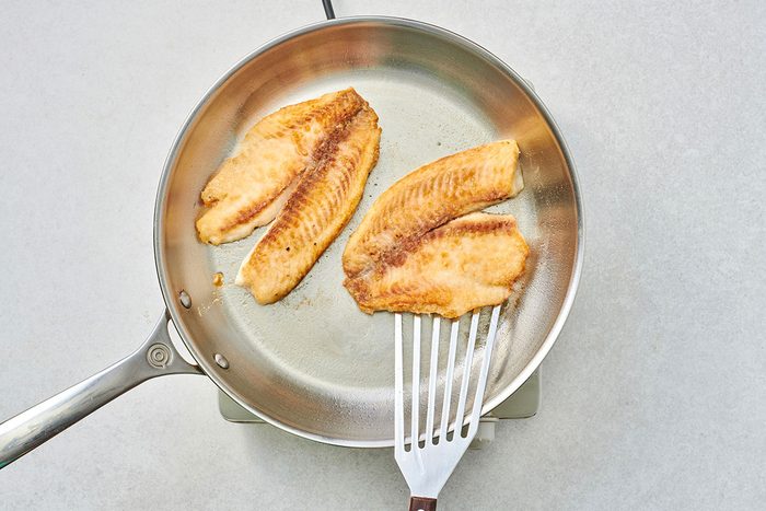 Cooked tilapia fillets in a skillet
