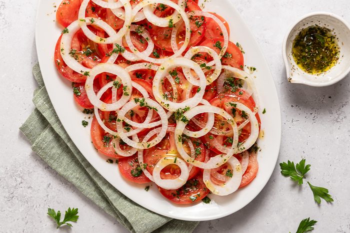 Serving Dish With Sliced Onions, Tomatoes And Seasoning